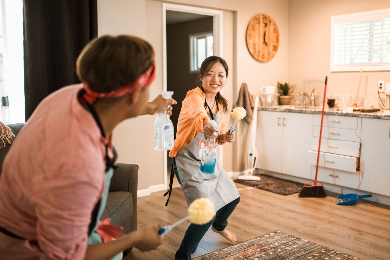 hero-img-02 A couple of Asian descent enjoying themselves while cleaning their home, creating a cheerful atmosphere.